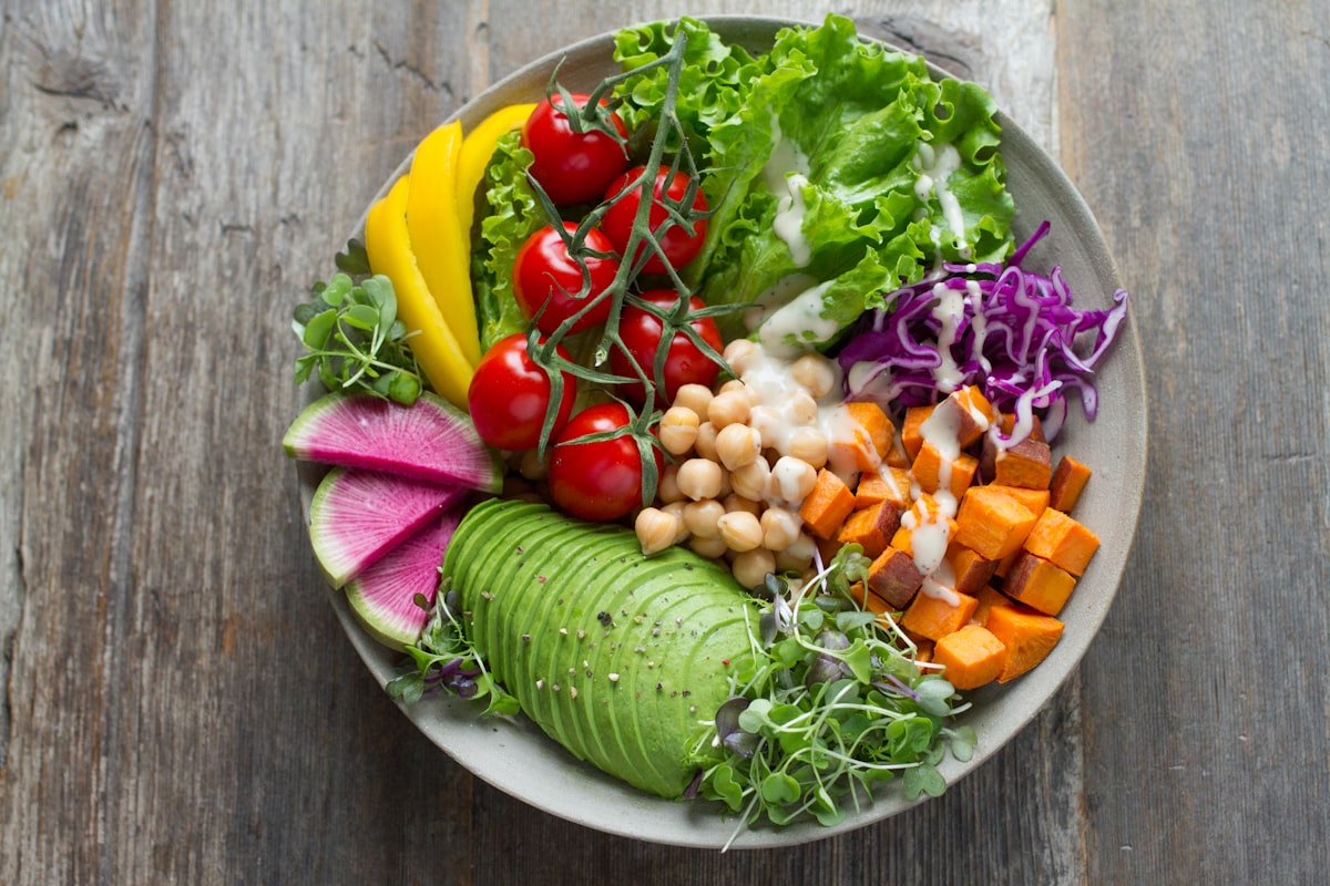 Variety of colourful vegetables including leafy greens, carrots, and bell peppers